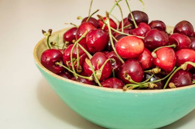 Beyaz arka planda kırmızı kirazları kaseye kapat