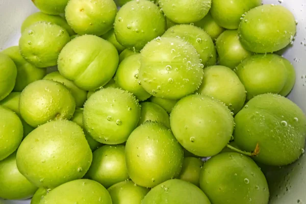 washed green plums in water