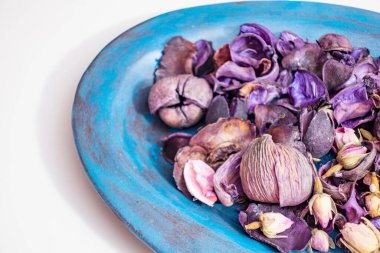 Bir kasede kurumuş gül yaprakları.