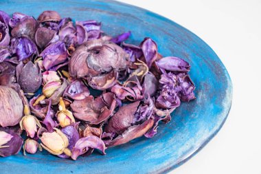 Bir kasede kurumuş gül yaprakları.