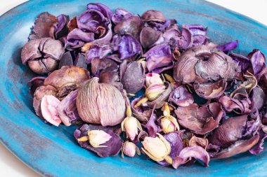 Bir kasede kurumuş gül yaprakları.