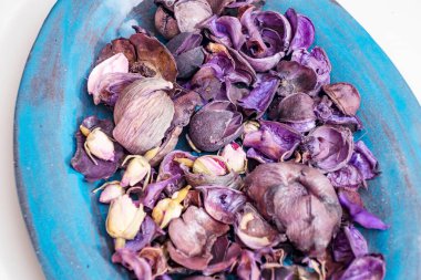 Bir kasede kurumuş gül yaprakları.