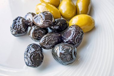 Siyah ve yeşil zeytinler beyaz tabakta