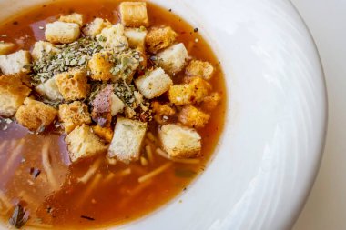 Geleneksel Türk çorbası, çıtır ekmek ve kekik yemeye hazır.