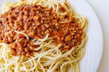 Beyaz tabakta domates soslu spagetti.