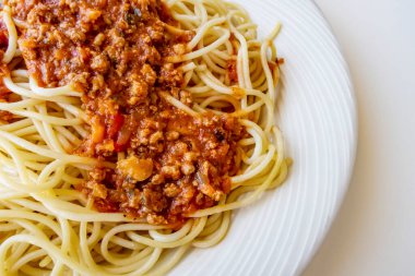 Beyaz tabakta domates soslu spagetti.