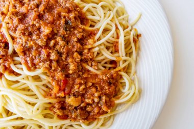 Beyaz tabakta domates soslu spagetti.