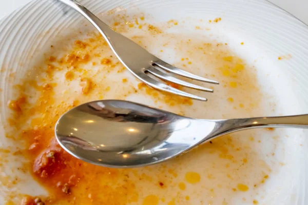 饭后勺子和叉子放在盘子里 — 图库照片