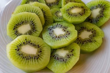 Dilimlenmiş kivi meyvelerini beyaz tabakta kapat