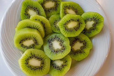 Dilimlenmiş kivi meyvelerini beyaz tabakta kapat