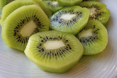 Dilimlenmiş kivi meyvelerini beyaz tabakta kapat