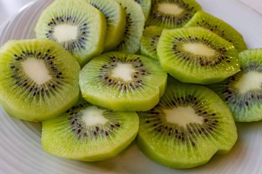 Dilimlenmiş kivi meyvelerini beyaz tabakta kapat