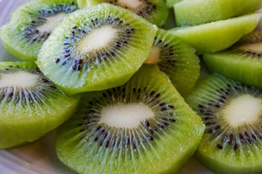 Dilimlenmiş kivi meyvelerini beyaz tabakta kapat