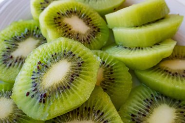 Dilimlenmiş kivi meyvelerini beyaz tabakta kapat