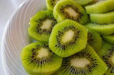 Dilimlenmiş kivi meyvelerini beyaz tabakta kapat