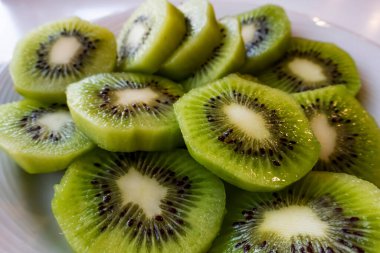 Dilimlenmiş kivi meyvelerini beyaz tabakta kapat