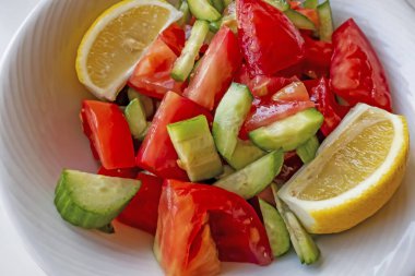 Domates, salatalık ve limon dilimli hazır salata.