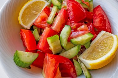Domates, salatalık ve limon dilimli hazır salata.