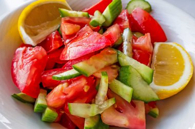 Domates, salatalık ve limon dilimli hazır salata.