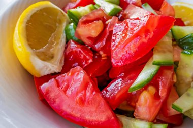 Domates, salatalık ve limon dilimli hazır salata.