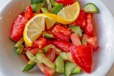 Domates, salatalık ve limon dilimli hazır salata.