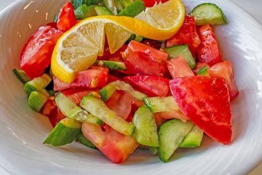 Domates, salatalık ve limon dilimli hazır salata.