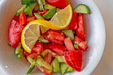 Domates, salatalık ve limon dilimli hazır salata.