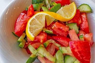 Domates, salatalık ve limon dilimli hazır salata.