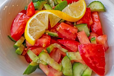 Domates, salatalık ve limon dilimli hazır salata.