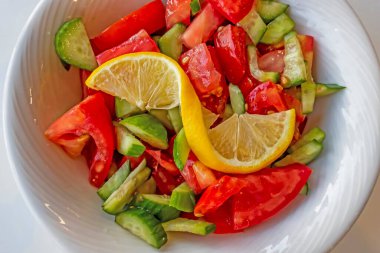Domates, salatalık ve limon dilimli hazır salata.