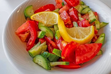 Domates, salatalık ve limon dilimli hazır salata.