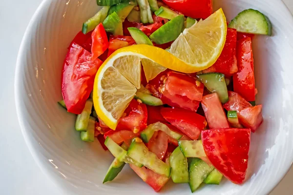 ready-to-eat salad with tomato, cucumber and lemon slice