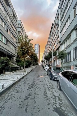 İstanbul, Türkiye. 8 Ekim 2025. İstanbul Sisli. Eski Sokağa Karşı Modern Gökdelen. Sabahın erken saatlerinde İstanbul, Sisli 'de. Konut binaları ve park edilmiş arabalarla dolu dar, huzurlu bir cadde dramatik bir gökdelene karşı modern bir gökdelenle çelişiyor..