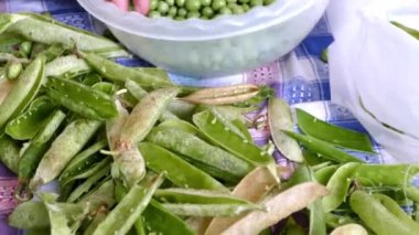 bir kadın bezelye taneleri kendi kabukları, taze doğal bezelye ve tahıl temizler