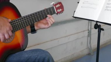 Müzisyen oynayan elektro gitar melodisi. Dizeleri ve sağ el manyetikler yakınındaki ayrıntıları.