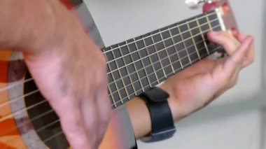 Müzisyen oynayan elektro gitar melodisi. Dizeleri ve sağ el manyetikler yakınındaki ayrıntıları.
