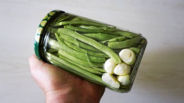 Kavanozda ev yapımı yeşil fasulye turşusu.,