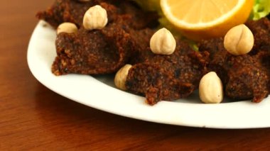 Çiğ Türk köftesi. Adam çiğ köfteye limon sıkıyor.,