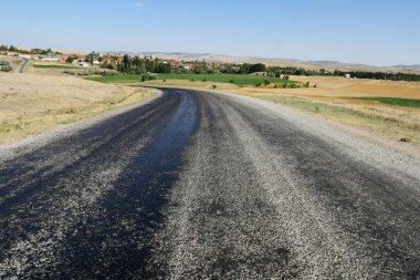 Yazın sıcaktan eriyen asfalt yolda zift ve asfalt yolda sıcak ve erimiş asfalt yollarda eridi.,