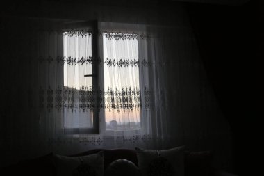 Sabahın ilk ışıklarıyla evin penceresinden doğan bir gündoğumu.,