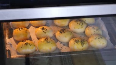 Susamlı çörekler fırında pişiyor, ev yapımı hamur ürünleri.,