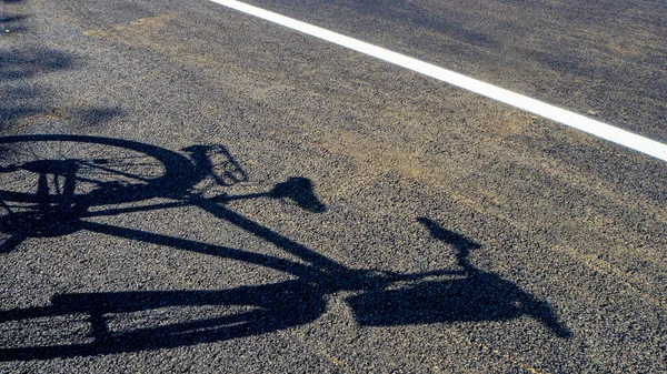 bike silhouette and shadow, bike shadow on asphalt road,