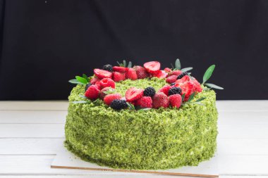 Taze böğürtlenli ıspanak yeşili kek. Yeşil pasta, yeşil bisküvi, çilek, ahududu, beyaz tahta.