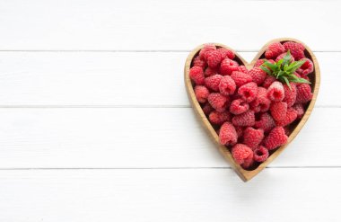 Tahta tabakta taze ahududu var. Kalp şeklinde böğürtlen