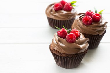 Taze ahududu ve beyaz arka planlı çikolatalı kekler.