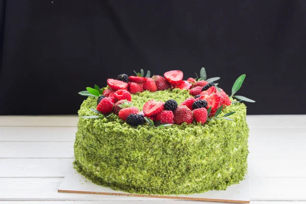 Taze böğürtlenli ıspanak yeşili kek. Yeşil pasta, yeşil bisküvi, çilek, ahududu, beyaz tahta.