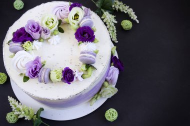 Taze çiçekler, badem kurabiyeleri ve kremayla süslenmiş güzel mor pasta. Kalp pastası. Aşk konsepti, düğün pastası, doğum günü pastası, anneler günü, 8 Mart, kadınlar günü, tasarım şablonu, siyah arkaplan