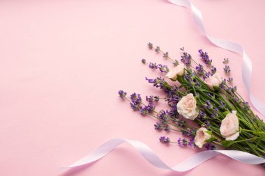 Çiçekler düz dizayn. Pembe güller ve pembe arka planda lavanta çiçekleri, beyaz kurdele. Lavanta maketi, provence şablonu, lavanta şablonu fotokopi alanı ve düğün düzeni olan tebrik kartları için.