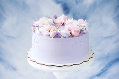 Güzel pastalar. Pembe gül çiçekli pasta, ahşap tezgahta mor kremalar. Düğün pastası, doğum günü pastası, Anneler Günü, 8 Mart, kadınlar günü, güllü pasta ve lavanta