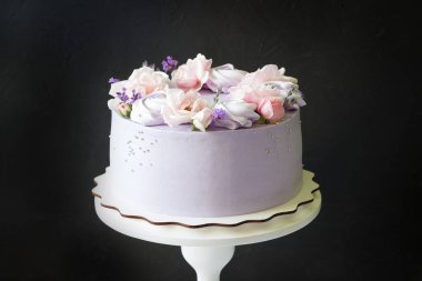 Güzel pastalar. Pembe gül çiçekli pasta, ahşap tezgahta mor kremalar. Düğün pastası, doğum günü pastası, Anneler Günü, 8 Mart, kadınlar günü, güllü ve lavantalı pasta, siyah arkaplan